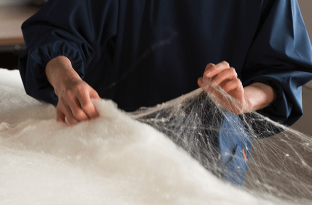近江真綿の特徴を活かし、職人が1枚1枚心を込めて丁寧に手挽きし重ねた、近江の技術で作られた、高品位な真綿